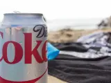 En burk Diet Coke på stranden, perfekt för den som vill undvika socker och hantera diabetes. Sukralos i drycken gör den till ett sockerfritt alternativ.