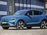 Niebieskie Volvo C40, elektryczny SUV coupe, parkuje przed budynkiem z numerem "02".