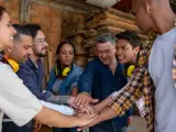 Grupa pracowników stolarni zjednoczona w geście solidarności. Ich połączone dłonie symbolizują siłę i wspólny cel, jak w dobrze działającym **związku zawodowym**.