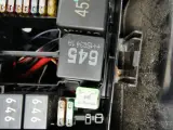 Wnętrze skrzynki z bezpiecznikami i przekaźnikami w Passacie B8. Widoczne przekaźniki z oznaczeniami 645 i 45, a także bezpieczniki.