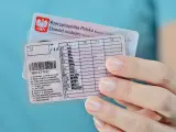 Dłoń trzyma polskie prawo jazdy z zaznaczoną kategorią B. Widoczny też dowód osobisty.