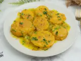 Patatas a la importancia, doradas y tiernas, bañadas en una salsa amarilla con perejil picado. Un plato que demuestra la importancia de las patatas en la cocina.