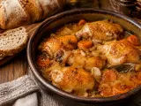 Muslos de pollo en salsa, una receta de la abuela que huele a hogar. Acompañados de pan rústico y zanahorias tiernas.