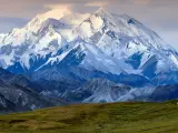 Majestatyczny, ośnieżony szczyt Denali, jednego z najwyższych szczytów kontynentów, góruje nad surowym krajobrazem.