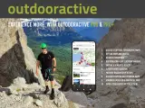 Escursionista sorridente in montagna, con smartphone che mostra l'app outdooractive gratis con mappe e percorsi.
