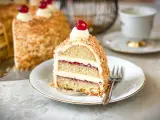 Ein Stück Frankfurter Kranz mit Buttercreme, Marmelade und Nüssen, garniert mit einer Kirsche. Ein Genuss für jeden Kaffeetisch.