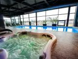 Relaks w hotelowym spa w Białymstoku: jacuzzi z bąbelkami i basen z widokiem na miasto.
