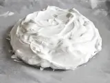 Puszysta beza pavlova na papierze do pieczenia, gotowa do wypieczenia.