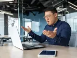 Mężczyzna w okularach gestykuluje, wyrażając frustrację. Czyżby jego słabe cechy charakteru dały o sobie znać podczas wideokonferencji?