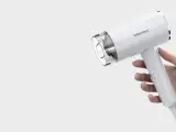 Biała suszarka Warmtec trzymana w dłoni.