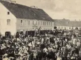 Tłum ludzi na targu w Biłgoraju, jakby żywcem wyjęty z legendy o tym mieście. W tle budynki i stragany.