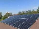 Panele fotowoltaiczne na dachu. Zastanawiasz się nad rozliczeniem rocznym czy miesięcznym? Słońce świeci, produkując czystą energię.