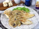 Sabroso pollo con champiñones en salsa cremosa, servido con lechuga fresca en un plato decorado.