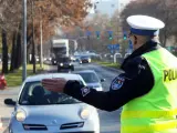 Policjant kieruje ruchem na ulicy. Kierowca zatrzymuje się, bo zgubił prawo jazdy i boi się kontroli.