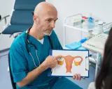 Lekarz omawia z pacjentką budowę macicy i możliwości leczenia mięśniaków macicy, wskazując na rysunek.