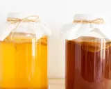 Dwa słoje z kombuchą, jeden jasnożółty, drugi ciemnobrązowy. Czy kombucha jest zdrowa? To pytanie nurtuje wielu miłośników napojów fermentowanych.