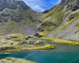 Un accampamento solitario ai laghetti di Ponteranica, tra montagne verdi e acque cristalline.