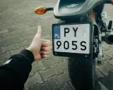 Kciuk w górę przy rejestracji starego motocykla z dokumentami. PY 905S.