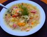 Syta zupa z kiszonej kapusty z ziemniakami i kiełbasą, ozdobiona koperkiem. Pyszne dania z kapusty na zimowe wieczory.