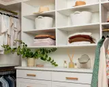 Un vestidor organizado con ropa colgada y doblada, cestas y sombreros. Ideas para como diseñar un vestidor funcional y estético.