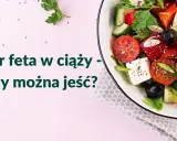 Sałatka z serem feta, pomidorami, ogórkiem i oliwkami na różowym tle.