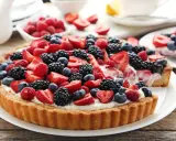 Tarta na cieście francuskim, obficie udekorowana świeżymi truskawkami, malinami, jeżynami i borówkami. Pyszny deser na letnie popołudnie.