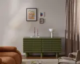 Un salotto moderno con divano color caramello, un mobile verde a coste e un gruppo di quadri appesi in modo originale.