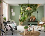 Une idée déco escalier mur avec un mur végétal luxuriant, un vélo vintage, des meubles en rotin et des coussins pastel.