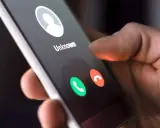 Dłoń trzyma smartfon z ekranem połączenia przychodzącego od nieznanego numeru. Dowiedz się, jak dzwonić z zagranicy do Polski na komórkę.