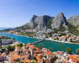 Widok na miasto Omis w Chorwacji z rzeką Cetina i górami w tle.