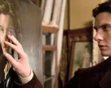 Un uomo osserva il suo ritratto, un'espressione di narcisismo e disturbi sessuali riflessa nel suo sguardo.