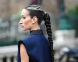 Eine Frau mit einem dicken, geflochtenen Zopf und Highlights. So kann man haare einfach stylen für einen eleganten Look.