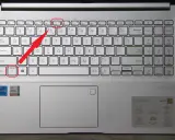 Klawiatura laptopa z podświetloną ikoną touchpada. Czerwona strzałka wskazuje klawisz Fn+Esc, który może aktywować touchpad.