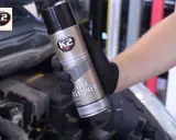 Ręka w czarnej rękawiczce trzyma puszkę K2 DPF Cleaner, zapobiegając ryzyku zapchania filtra cząstek stałych w Citroen C4.