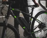 Czarny rower elektryczny z zielonymi akcentami i baterią Green Cell. Dowiedz się, jak sprawdzić baterię w rowerze elektrycznym.