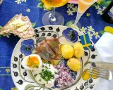 En härlig sillunch midsommar med färskpotatis, ägg, gräddfil och rödlök. En svensk flagga vajar glatt.