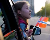 Dziewczynka z norweską flagą w ręku, wyjeżdża z kraju. Sprowadzenie auta z Norwegii to początek nowej przygody.