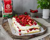 En vacker Pinocchiotårta med grädde och bär, perfekt för sommaren. Receptet kan hittas online.