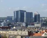 Nowoczesne wieżowce górują nad dachem kamienicy w największym mieście w Polsce.