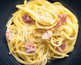 Spaghetti Carbonara mit herzhaftem Speck, cremig und mit frisch geriebenem Parmesan bestreut. Ein Klassiker, der immer schmeckt.