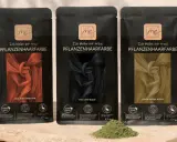 Drei Packungen Pflanzenhaarfarbe in Rot, Schwarz und Blond. Natürliche hairstyling produkte für eine schonende Farbveränderung.