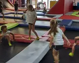 Dzieci skaczą na trampolinach w parku rozrywki. To świetne gorzów wielkopolski atrakcje dla dzieci, pełne radości i ruchu.
