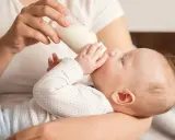 Dziecko pije mleko z butelki. Od kiedy mleko krowie zamiast modyfikowanego, maluch rośnie jak na drożdżach.