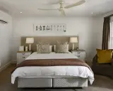 Chambre confortable avec lit douillet, prête à mettre en location sa résidence principale. Climatisation et ventilateur de plafond pour un séjour agréable.