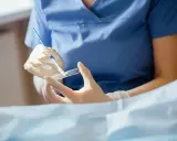 Lekarz w rękawiczkach przygotowuje preparat do badania cytologicznego, które pozwala wykryć zmiany w komórkach.