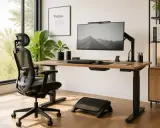 Un bureau bien organisé avec une chaise ergonomique, un écran d'ordinateur, un clavier et une plante verte. L'espace est lumineux et invitant.