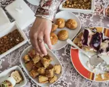 Ein Tisch voller Köstlichkeiten für das Ramadan Fest: Baklava, Kekse, Mandeln und ein Stück Kuchen.