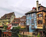 Case colorate e a graticcio lungo un canale, un'incantevole scena tra le città europee da visitare, con decorazioni natalizie.