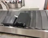 Dwa bagaże, w tym czarna walizka, czekają na odbiór na taśmie bagażowej. To typowy widok po przylocie liniami Ryanair.