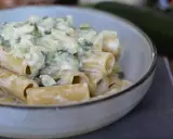 En krämig zucchini pasta i en skål, med en hel zucchini i bakgrunden.